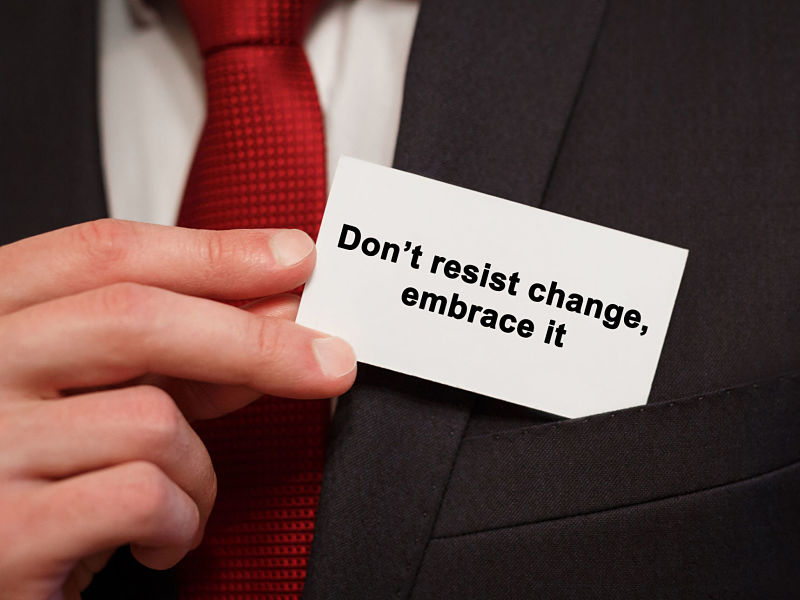 usinessman putting a card with text don’t resist change embrace it in the pocket