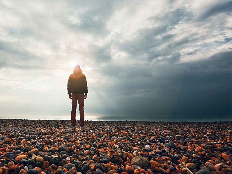 Man on beach looking at the horizon,