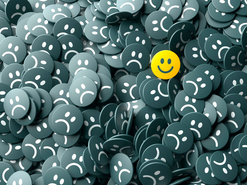 Happy face in the middle of sad faces