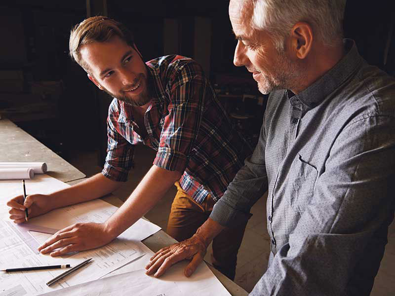 father and son looking over building plans
