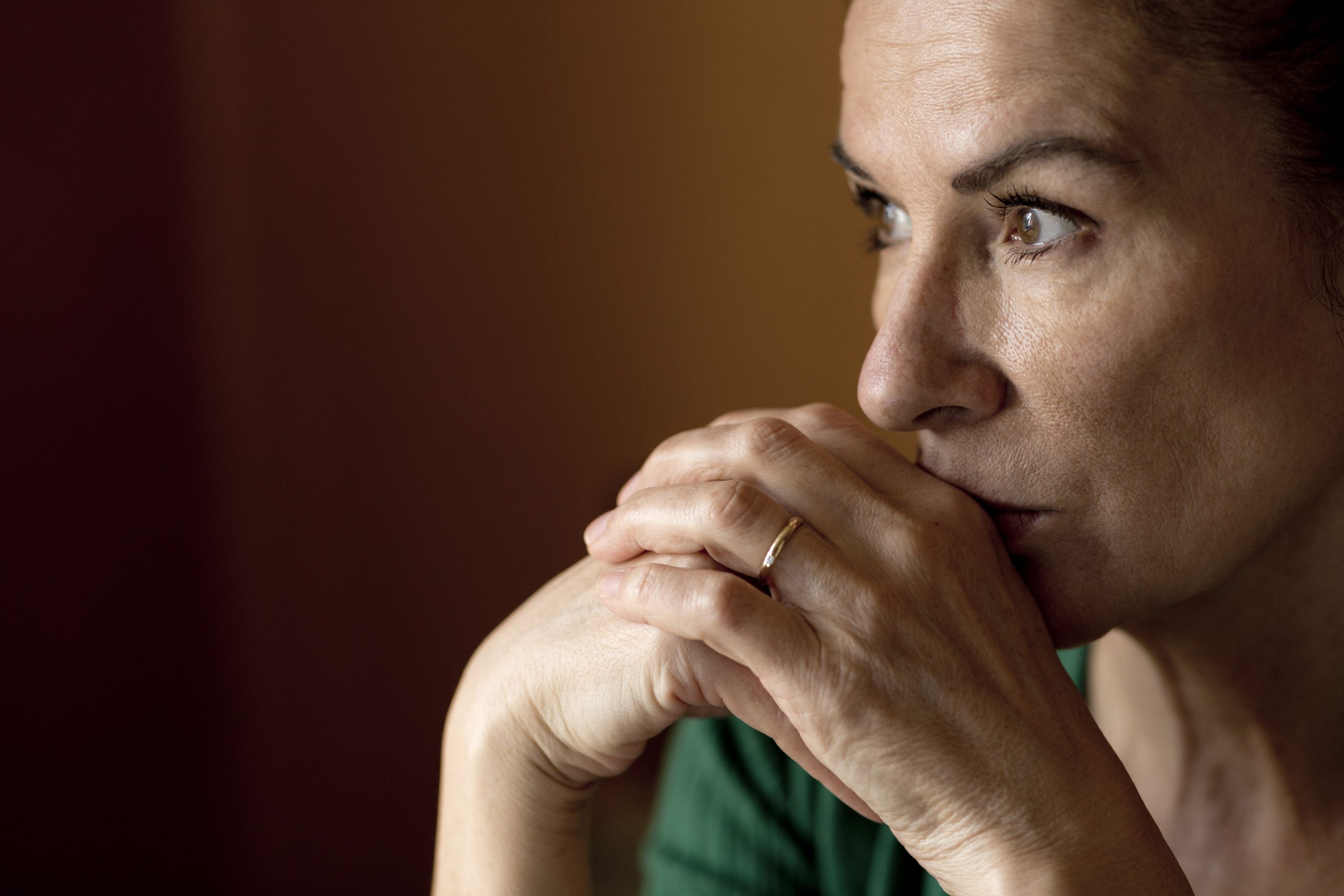 Thoughtful lonely mature woman looking away at home during curfew