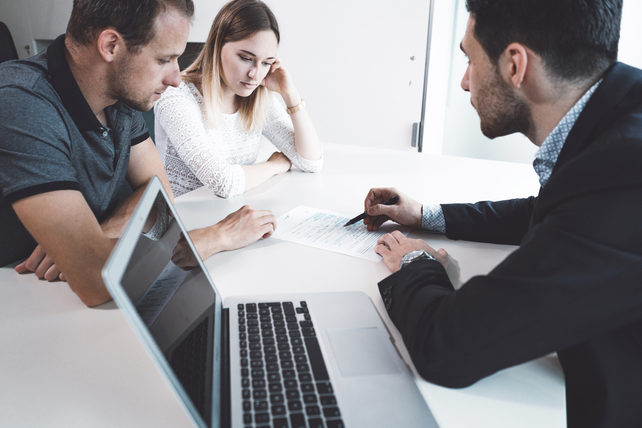 Unhappy young couple at meeting with lawyer about divorce