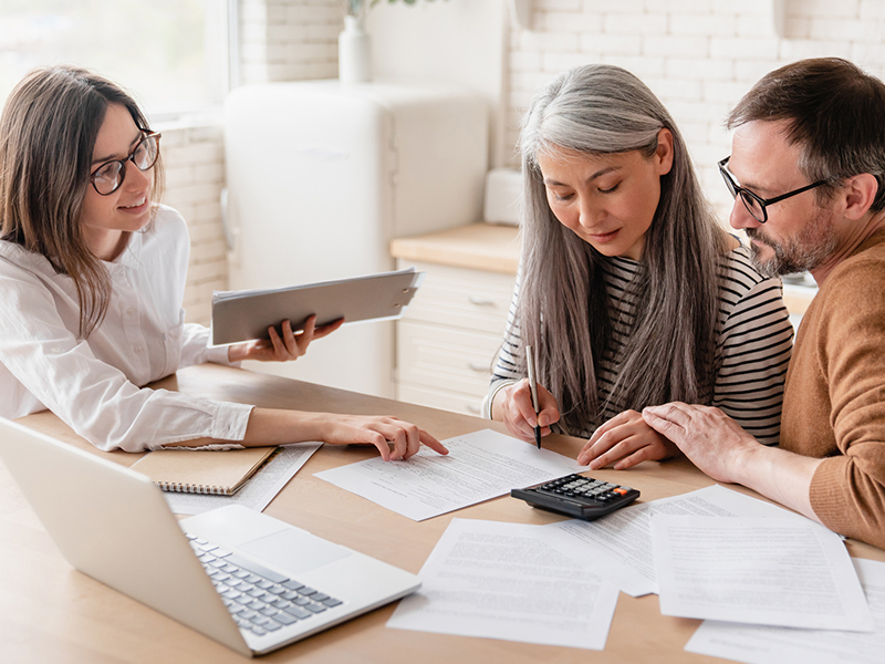 Woman consulting mature family couple, discussing investments