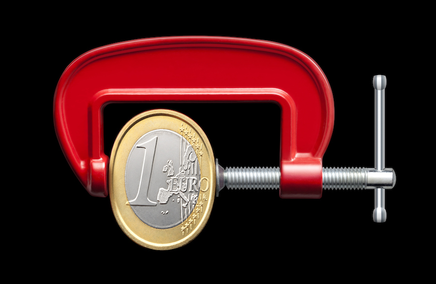 Euro coin being squeezed in a vice