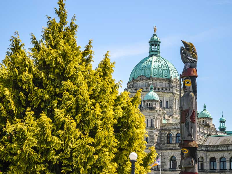 The Victoria government building beside an aboriginal totem pole.