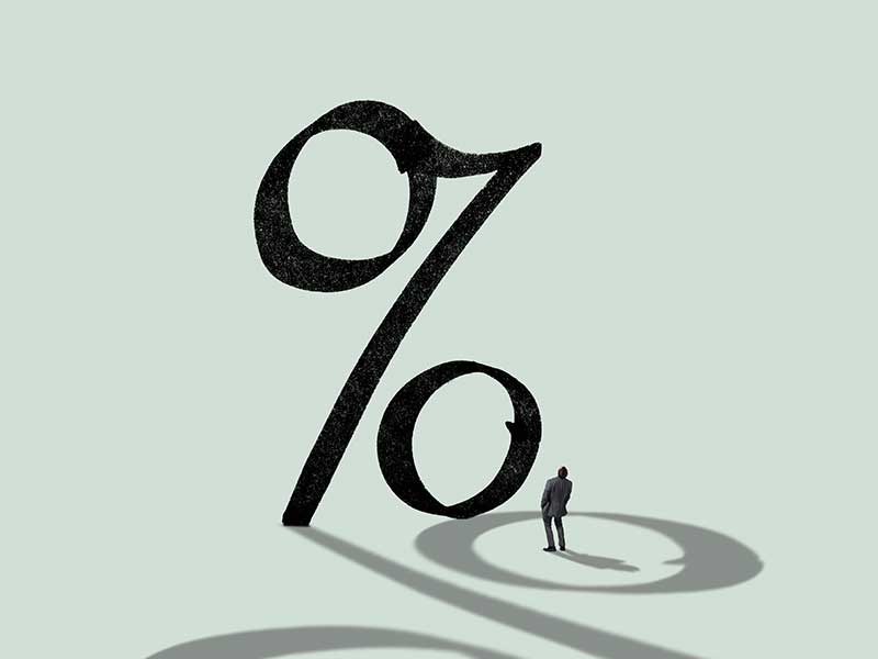 Businessman in front of giant percentage sign