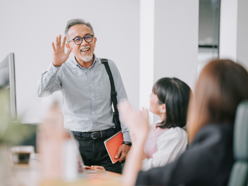 senior colleague back to work with face mask greeting on each other in office morning stock photo