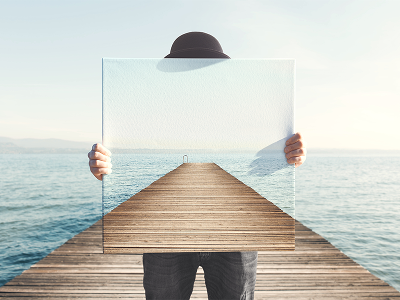 Man holding a surreal painting of a boardwalk