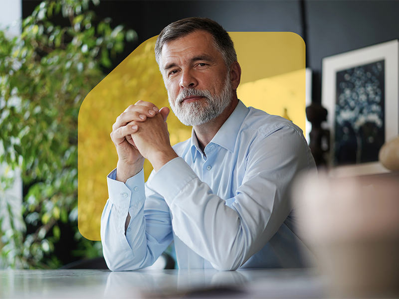Mature professional businessman with grey hair looking at camera and smiling.