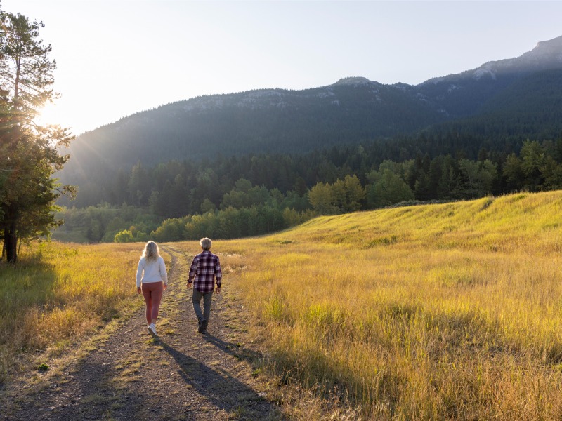 Mature couple walking along a rural road at sunrise