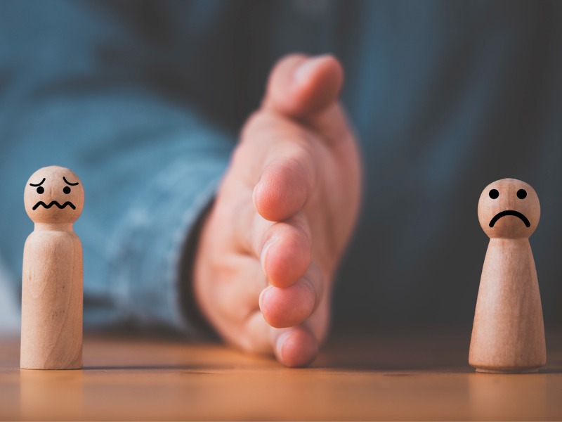 Hand blocking and divide between man and woman wooden figure for resolving conflict