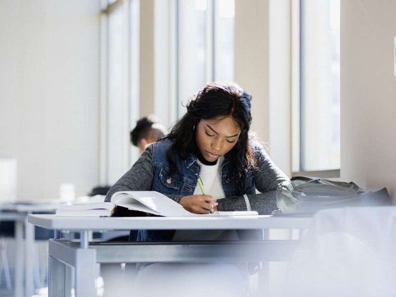 Focused young woman doing homework