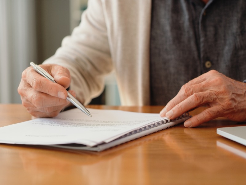 Older person signing a contract