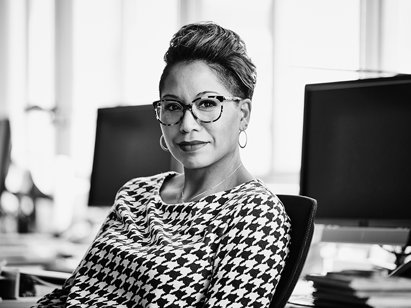 Smiling businesswoman seated at office workstation.