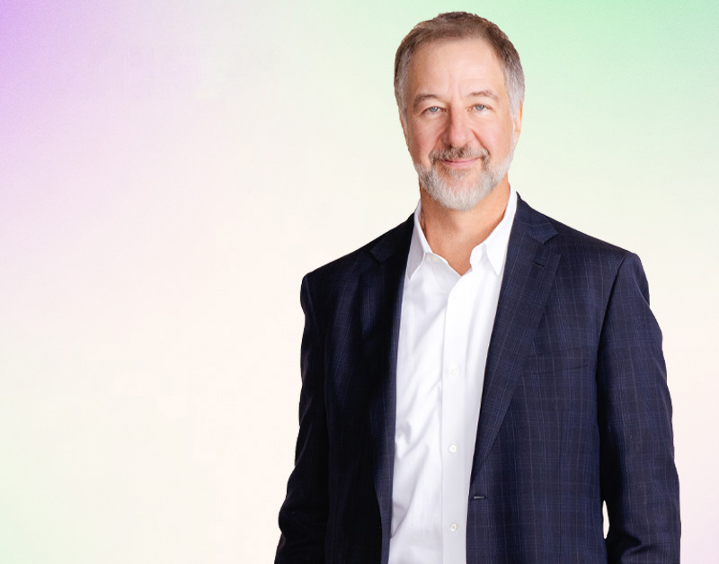 David Picton standing with a colorful background behind him.