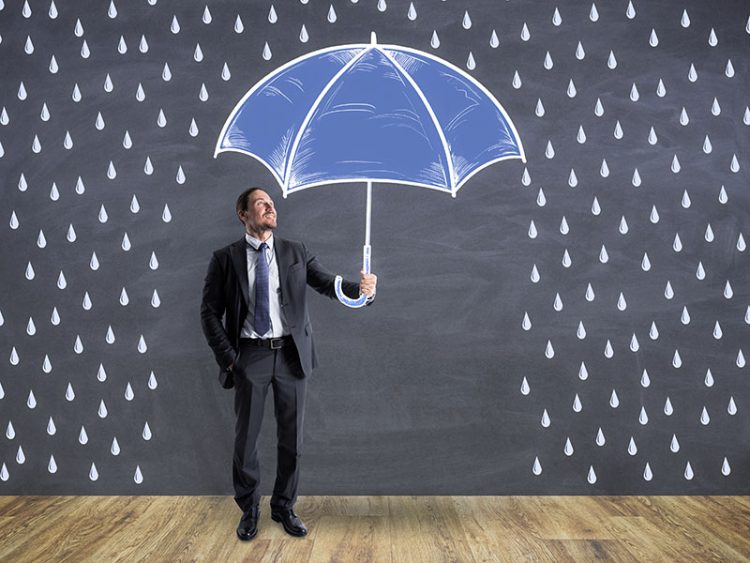 businessman holding an umbrella and staying dry while it rains
