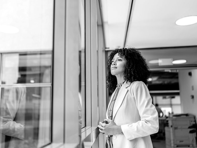 Businesswoman contemplating and looking out the window, in the office